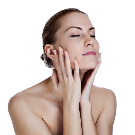 Beautiful young woman massaging her faceの写真素材