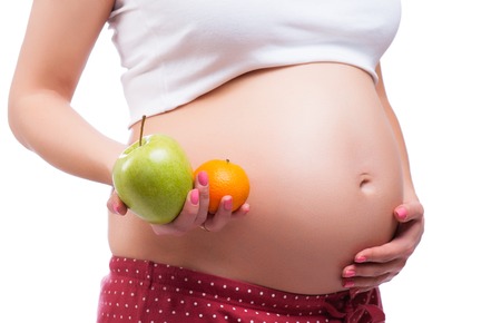 healthy nutrition and pregnancy. pregnant woman's belly and healthy foodの写真素材