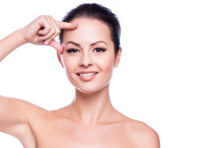 Beautiful Young Woman Touching Her Face.Fresh Healthy Skin.Isolated on Whiteの写真素材