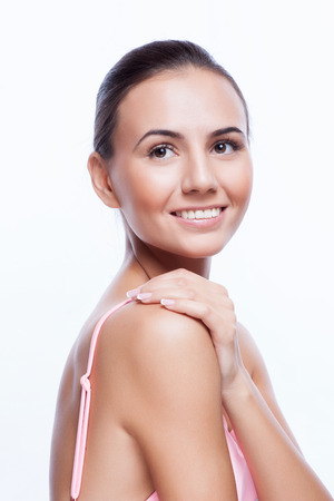 Beautiful Young Woman Touching Her Face.Fresh Healthy Skin.Isolated on Whiteの写真素材