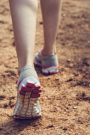 Runner feet running on road closeup on shoe. woman fitness sunrise jog workout welness concept.の写真素材