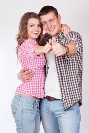 Portrait of happy couple with thumbs up sign isolated on white backgroundの写真素材
