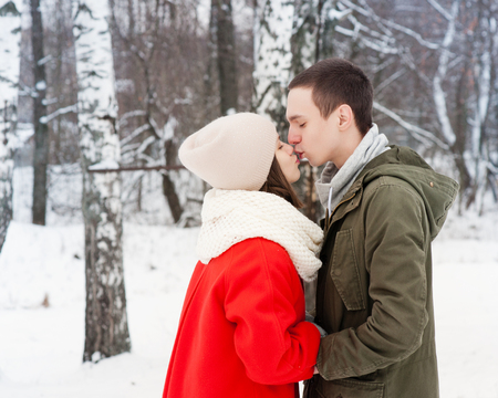 Happy Young Couple in Winter Park having fun.Family Outdoors. love kissの写真素材