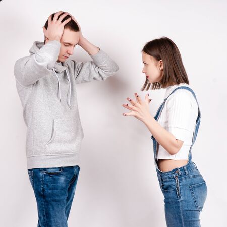 Portrait of an angry couple shouting each other against white background.の写真素材