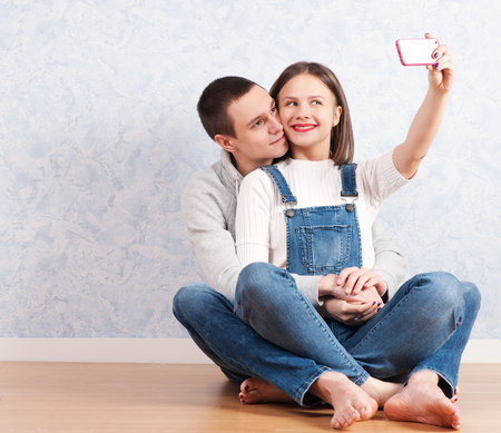 Capturing happy moments together. Happy young loving couple making selfie.の写真素材