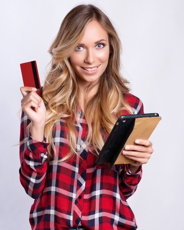 Happy young woman with credit card using tablet pc.の写真素材