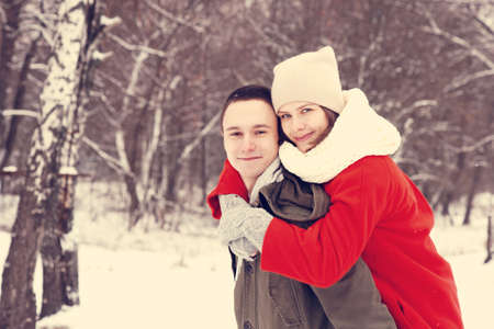 Embracing couple looking at camera with smiles in winter park.の写真素材