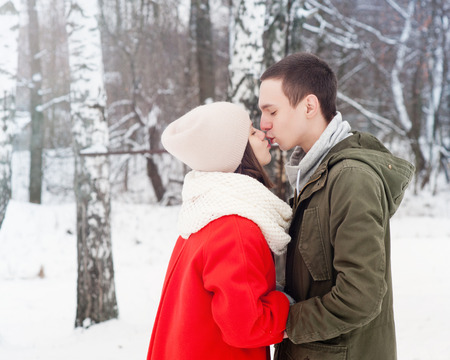 Happy Young Couple in Winter Park having fun.Family Outdoors. love kissの写真素材