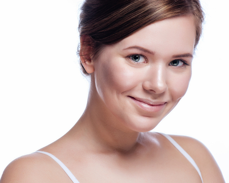 Beautiful face of young adult woman with clean fresh skin - isolated on white.の写真素材