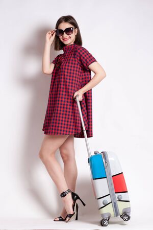 portrait of Happy girl going on vacation walking with suitcase and smile.の写真素材