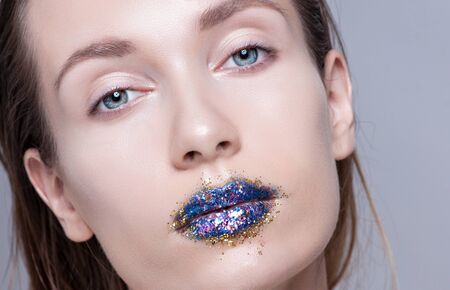 beautiful model with natural make-up and blue glitter lips.の写真素材