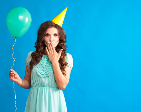 Smiling girl with balloons on a blue background isolated.の写真素材