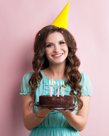 Woman blows out the candles on a birthday cake.の写真素材