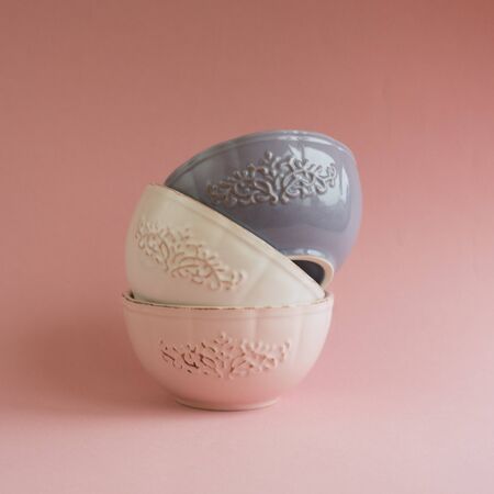 Six ceramic bowls in a stack. Isolated on pink background.の写真素材