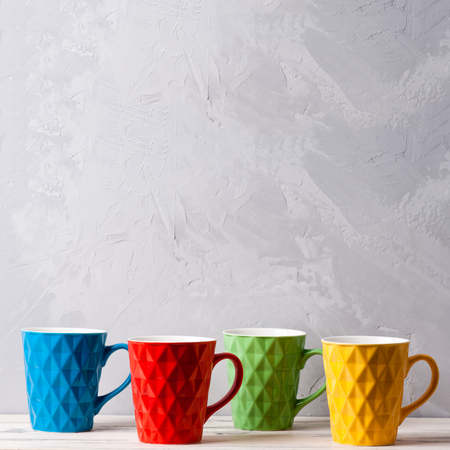Set of four colored cups for coffee on a gray background.の写真素材