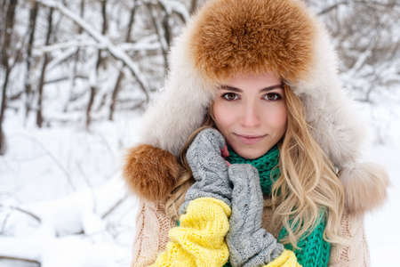 Beautiful winter portrait of young woman in the winter snowy scenery.の写真素材