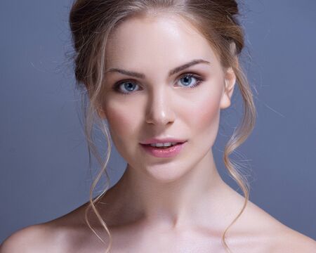 Portrait of wonderful young blonde woman with long hair looking at cameraの写真素材