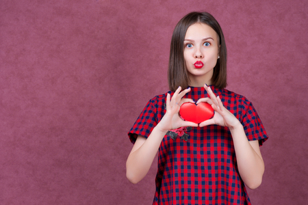 Love and valentines day woman holding heart smiling cute and adorable isolated on pink background.の写真素材