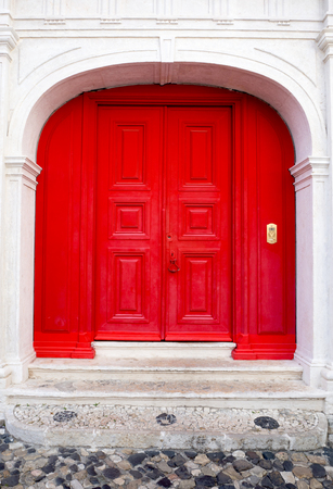 Red entrance door in front of residential house.の写真素材