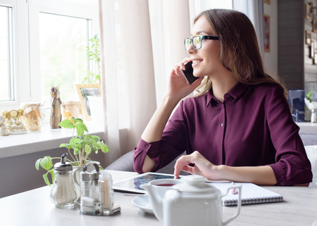 Close up of women's hands holding cell telephone with blank copy space scree for your advertising text message or promotional content, hipster girl watching video on mobile phone during coffee break.の写真素材