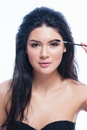 Eyebrows Care. Closeup Of Woman Beautiful Blue Eye, Perfect Shaped Brow, Long Eyelashes With Professional Makeup And Brow Gel Brush. Young Female Model Shaping Brown Eyebrows. High Resolution Image.の写真素材