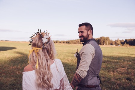 Lovely young couple in wedding dresses in Bohho style, on a field with a balloon.の写真素材