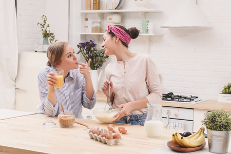 Two cheerful friends cook together. Friends Chef Cook Cooking Concept.の写真素材