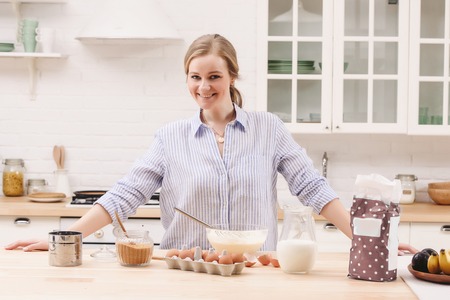 Portrait of beautiful young woman having breakfast in the kitchenの写真素材