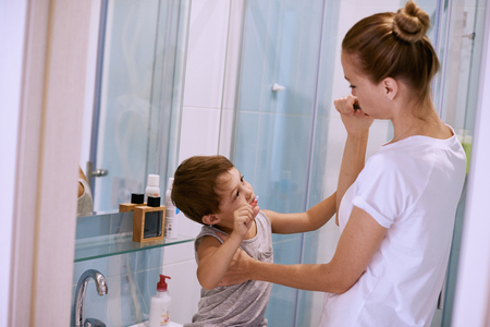 mother teaching kid teeth brushing at homeの写真素材