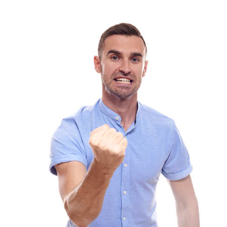Casually handsome. Confident young handsome man in jeans shirt keeping arms crossed and smiling while standing against white background.の写真素材