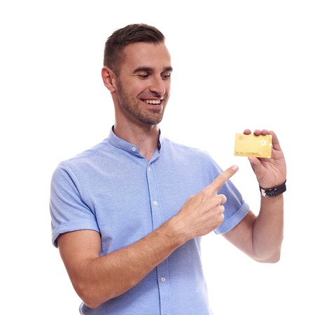 Happy smiling young man showing credit card isolated on white backgroundの写真素材