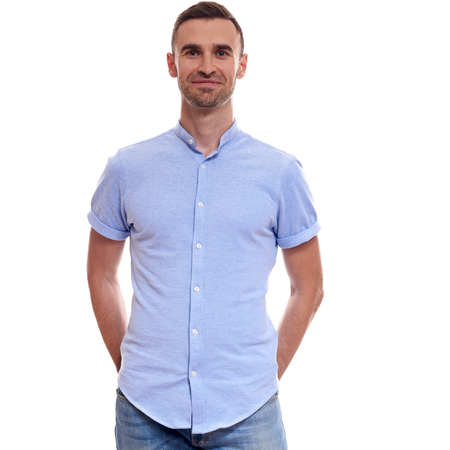Casually handsome. Confident young handsome man in jeans shirt keeping arms crossed and smiling while standing against white background.の写真素材