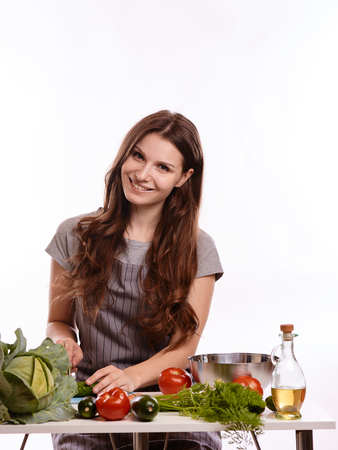 happy adult woman with various fresh vegetables on kitchen table looking at camera.の写真素材