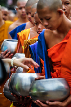 Giving to aims of thai monks  Thailand merit to the early days of Buddhist monks  At Nongkhai City, North East of Thailand のeditorial素材