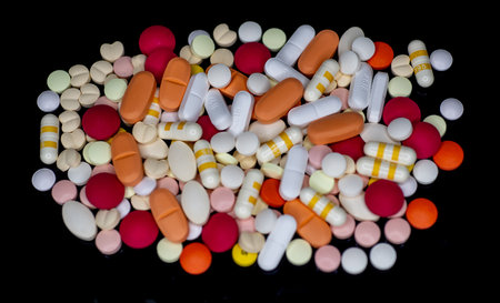Colorful pills isolated on black background. Top view. Close up.