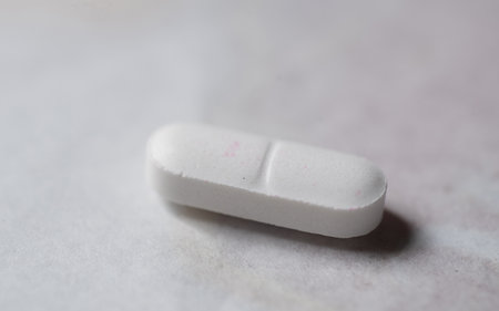 Close up of a white pill on a white background with copy spaceの写真素材