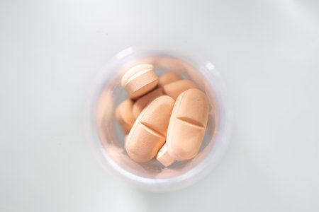 Pills in a plastic container on a white background. Close-up.