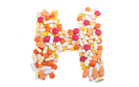 Letter H of the English alphabet made of pills isolated on white backgroundの写真素材