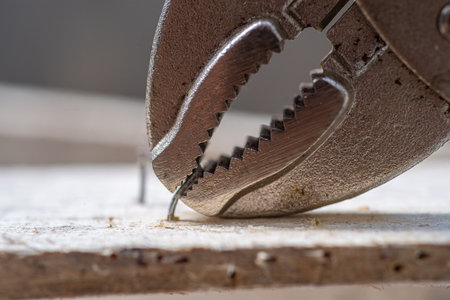 Closeup of a pliers working on a piece of wood.の写真素材