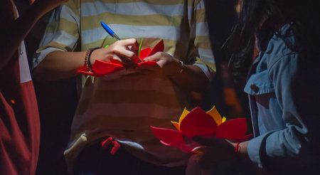 Locals prepare vibrant flowers to float down the river in a heartfelt tribute to their loved ones, honoring love and gratitude on this special day of remembrance and respect.の写真素材