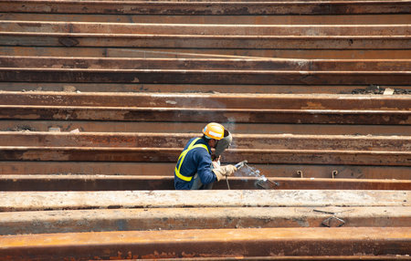 Worker welding steel structure at construction site, closeup of photoの写真素材