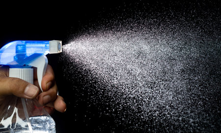 Spray bottle on black background. Cleaning and disinfection concept.