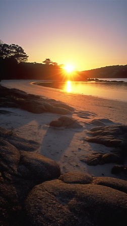Beautiful sunset at the beach with rocks and sunbeams.の素材