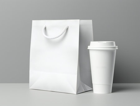 White paper bag and coffee cup on gray background.の素材