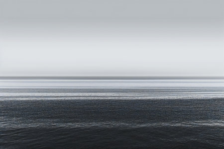 Dark moody seascape with calm water and clouds on horizonの素材
