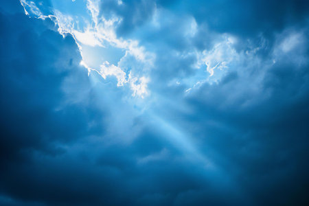 Dark stormy sky with clouds and sunbeams, natural backgroundの素材