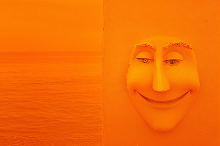 Smiling face on the orange wall in the sea, Thailand.の素材