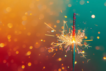 Burning sparkler on colorful bokeh background. New year and Christmas partyの素材