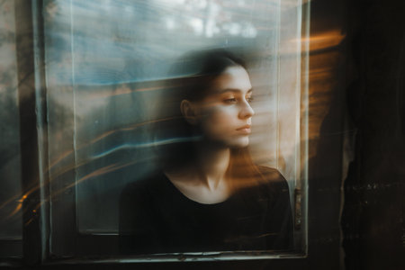 portrait of a girl in a black T-shirt in the windowの素材