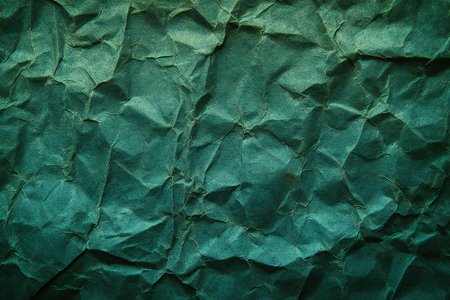 Green crumpled paper background. Texture of wrinkled paper.の素材